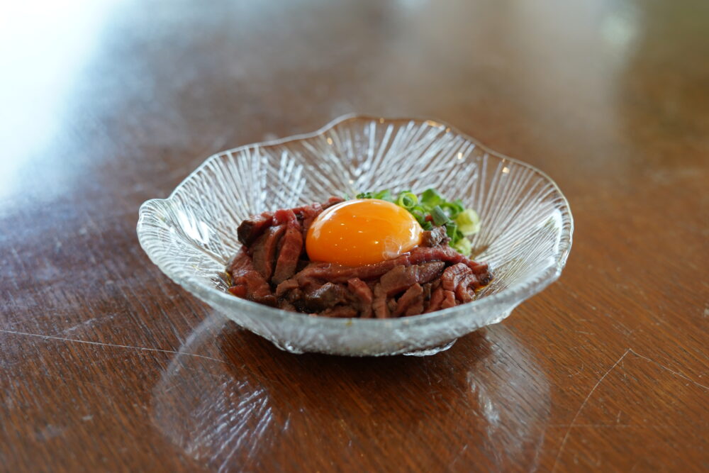やわらかなローストビーフに、ユッケ仕立ての濃いめの味付けを合わせた一品。肉の旨みと濃厚なタレが特徴。